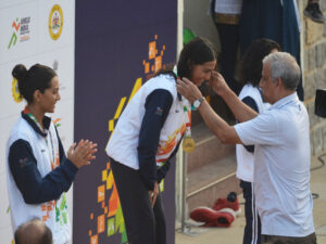 Triple Olympian hockey star MM Somayya presents the 100m Breaststroke Gold medal to Jyoti Patil University of Mumbai. Her twin Aarti Patil left secured the silver